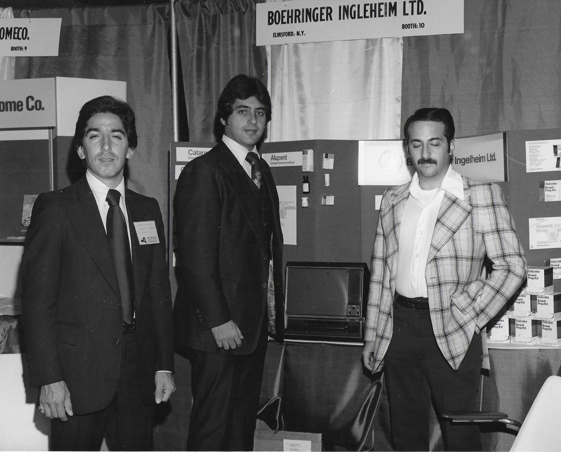 Three men standing in front of exhibit booth