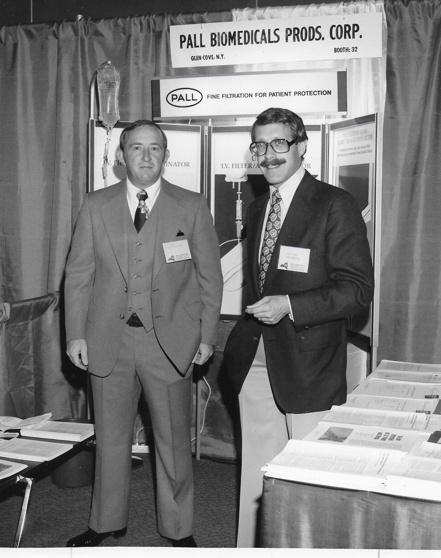 Two men smiling at exhibit booth