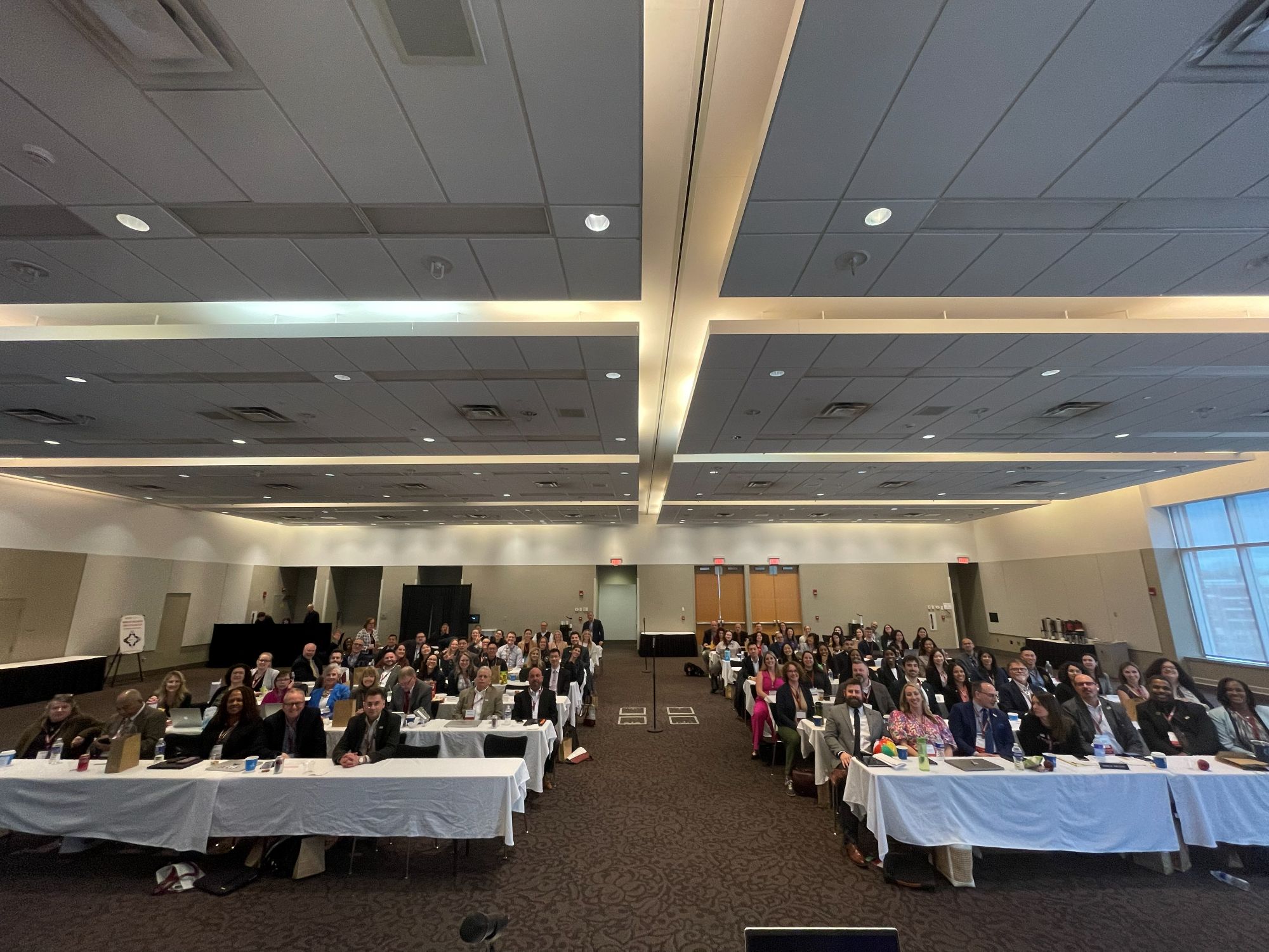 View of th eHall of Delegates from the front with many people sitting in place and smiling for the photo