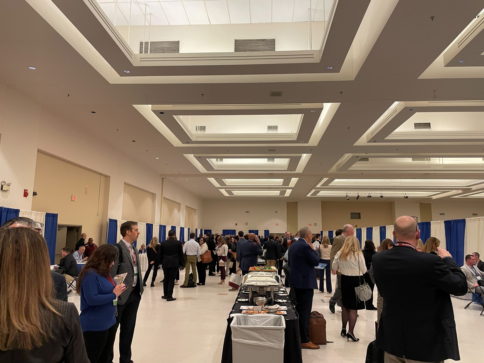 A large group standing around and inspecting the Reverse Exhibit at the conference